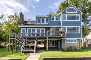 A two-story house with a covered porch and a staircase leading to the upper level. - New Waterfront Thomas Point Retreat with Private Beach, Dock, Billiards & Parking (Annapolis)