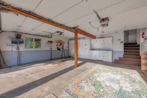 A spacious room with a concrete floor, a large rug, and a wooden beam structure. - Hall Court Overlook - Hot Tub (Stateline)
