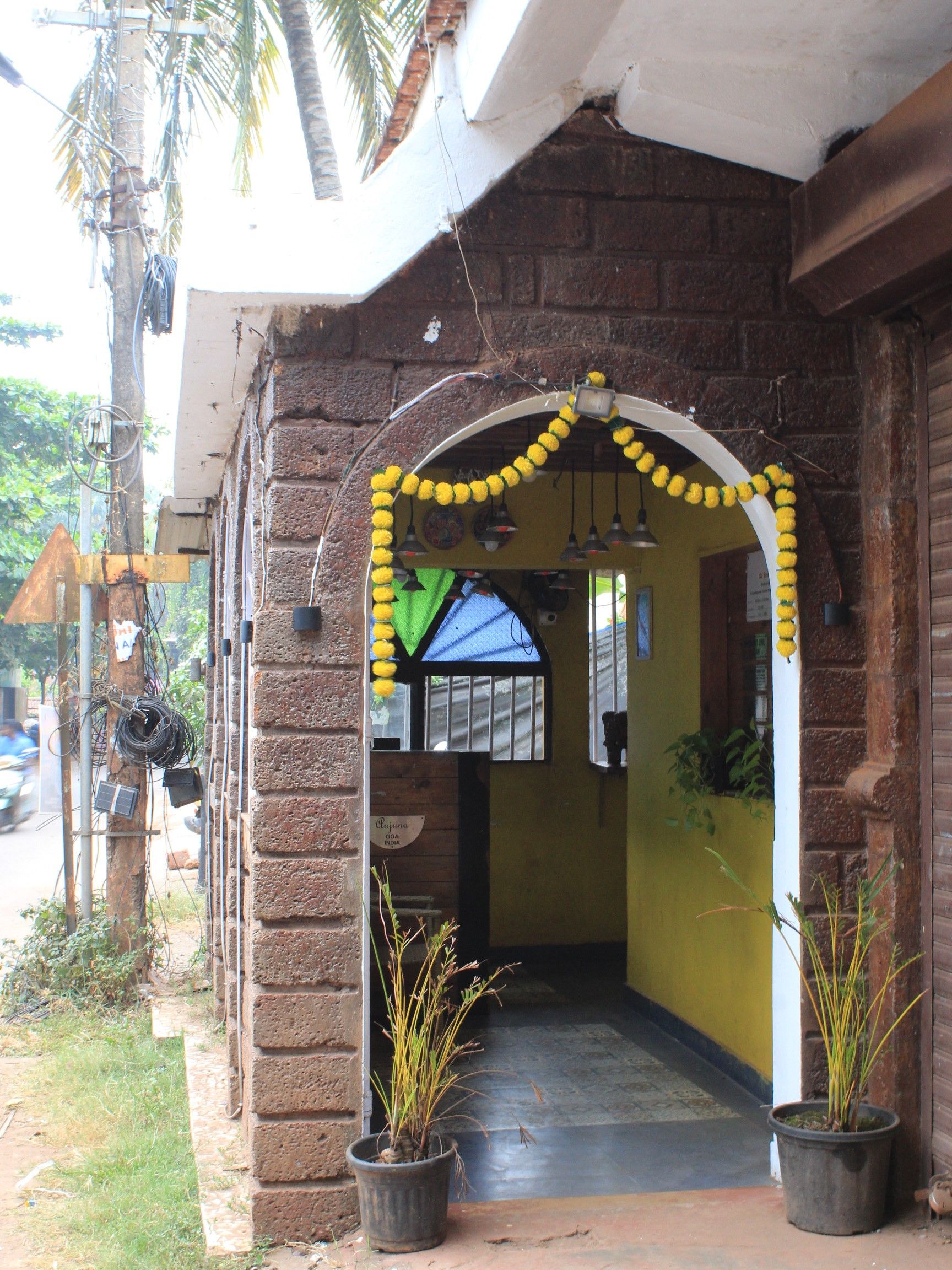 Uma entrada com arco decorativo e uma placa indicando 'Cajuna Goa India'.