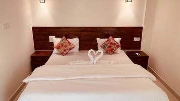 A hotel room with a large bed, two nightstands, and two wall-mounted light fixtures.