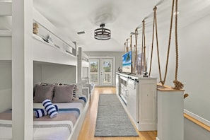 A narrow hallway with bunk beds on one side and a kitchenette on the other. - The Windquest Inn 3B / 3.5B + Den Private Canal Home by RVA (Longboat Key)