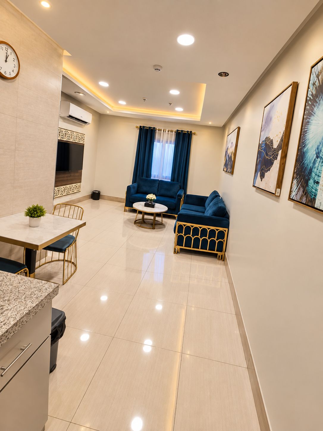 A modern living room with a sofa, a coffee table, and a TV mounted on the wall.