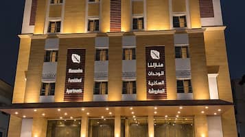 A multi-story building with signage for Manazeln Furnished Apartments.