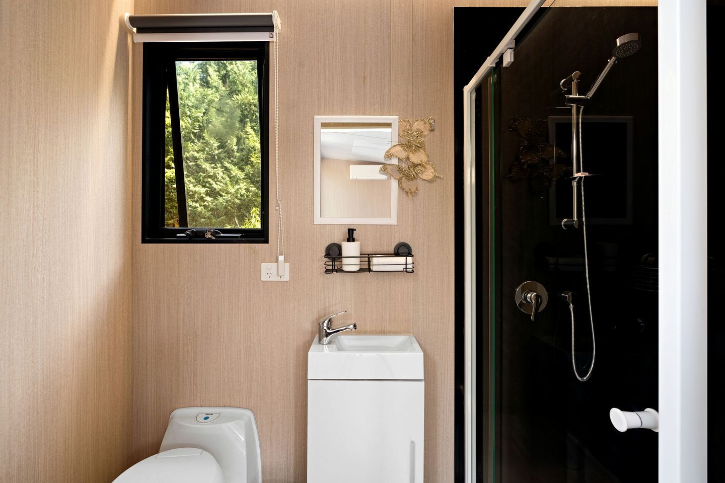 A modern bathroom with a toilet, sink, and shower.