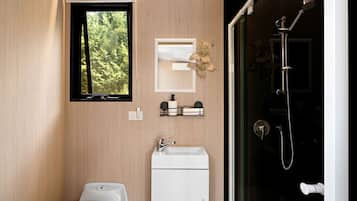 A modern bathroom with a toilet, sink, and shower.