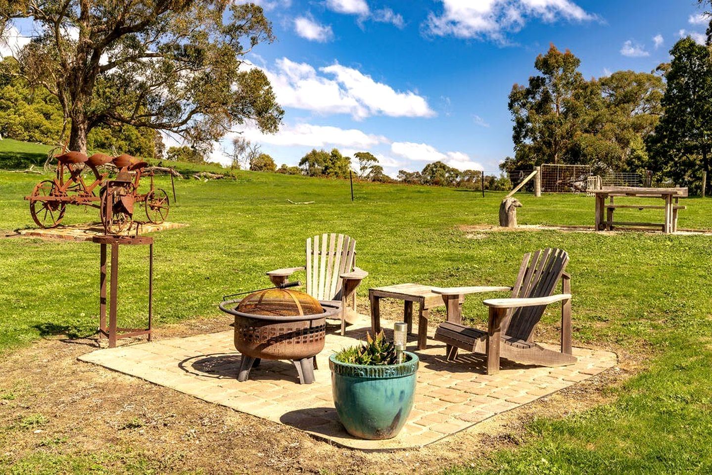 An outdoor seating area with a fire pit, chairs, and a table.