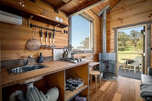 Un intérieur en bois comprenant une cuisine, un coin repas et une vue sur l’extérieur.