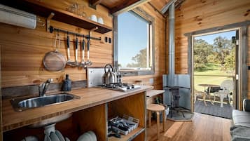 Un interior de madera con cocina, comedor y vistas al exterior.