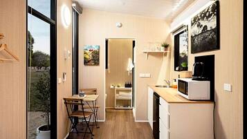 A compact kitchen with a dining area, a microwave, and a small refrigerator.