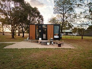 A modern, compact cabin with a wooden exterior, a small porch area, and a fire pit. - Ballarat Bliss in Wendouree, Victoria (Wendouree)