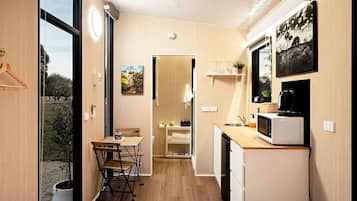 A compact kitchen with a dining area, a microwave, and a small refrigerator.