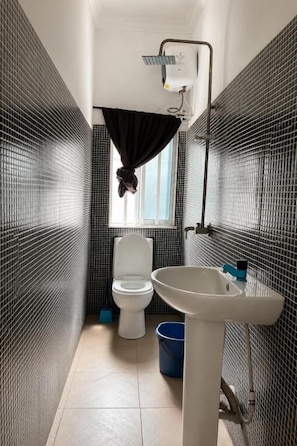 A bathroom with a toilet, sink, and shower. - Caligeo Suites I (Ibadan)
