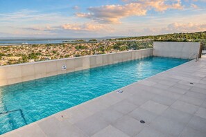 A swimming pool with a view of a coastal town and a body of water in the distance. - Ocean Bloom | Sea Views, Beach, 3BR & Pool (Cartagena)