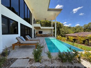 A modern house with a swimming pool, outdoor seating, and a balcony overlooking the greenery. - Casa Pura Aventura | Pool, Views & Coastal Luxury (Playa Hermosa)