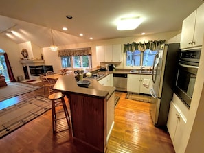 Una cocina moderna con una isla central, suelo de madera y electrodomésticos integrados.