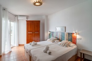 A hotel room with two beds, a wardrobe, a shower, and a view of the outside. - Apartment in Nerja by Torrecilla Beach (Nerja)