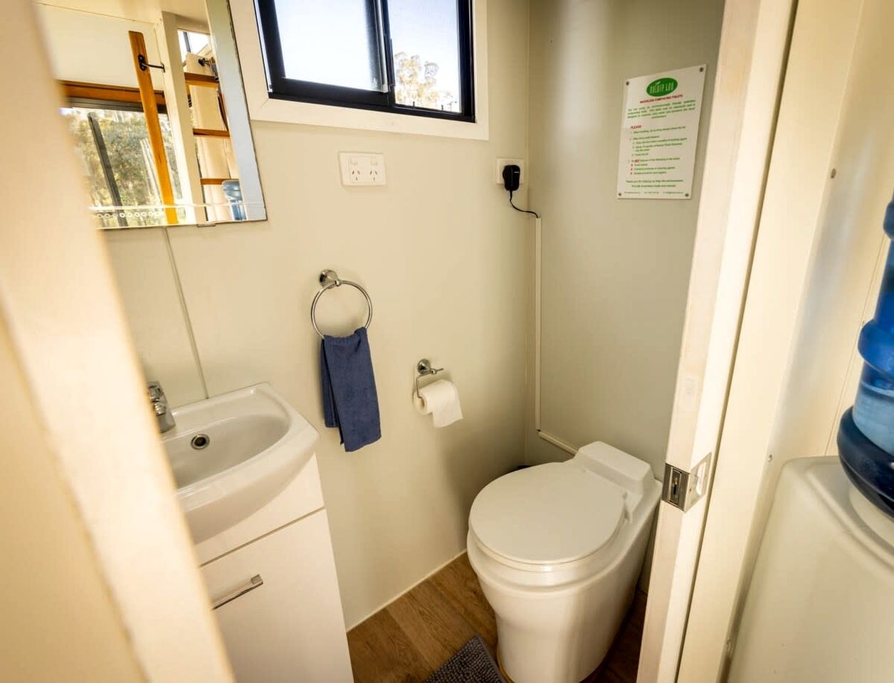 Ein kleines Badezimmer mit Waschbecken, Toilette und Fenster.