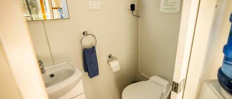 Ein kleines Badezimmer mit Waschbecken, Toilette und Fenster.