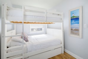 A bunk bed with a window, a painting of a lighthouse, and a power outlet on the wall. - Short Walk To Sand, Prefect for Families, Large Deck! (Newport Beach)