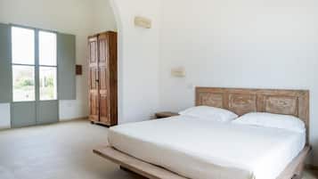 A bedroom with a bed, wooden headboard, and a wardrobe.