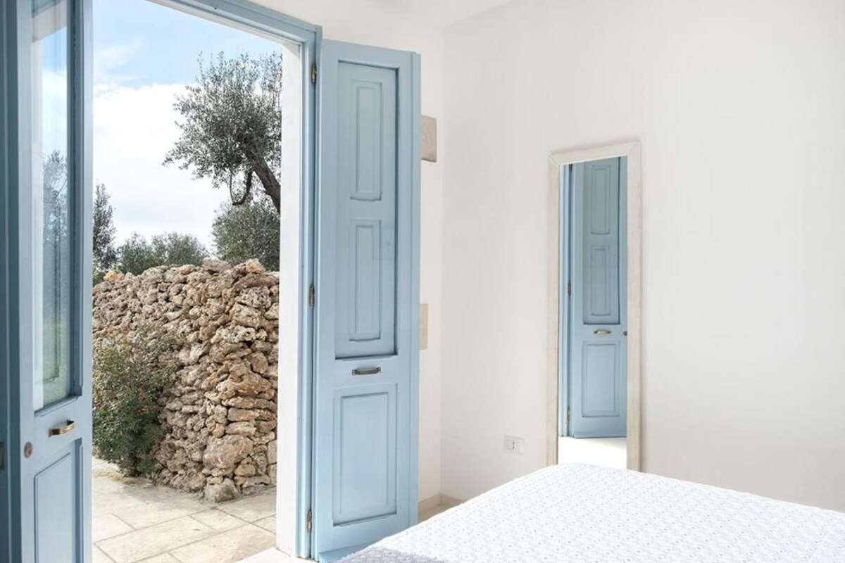 Une chambre à coucher avec un lit, un mur en pierre et une porte bleue.