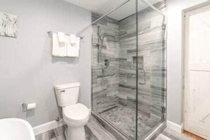 Une salle de bain avec une douche à parois de verre, des toilettes et un lavabo blanc.