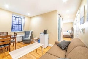 Een knus woongedeelte met een bank, een eettafel en een kitchenette.