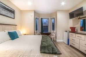 Une chambre à coucher avec un lit, un bureau, une chaise et un téléviseur.