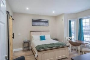 Une chambre à coucher avec un lit, des tables de chevet, une chaise et une table.