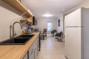 A kitchen with a wooden countertop, a sink, and a refrigerator. - Riverside Inn - Unit 7 (New Glasgow)