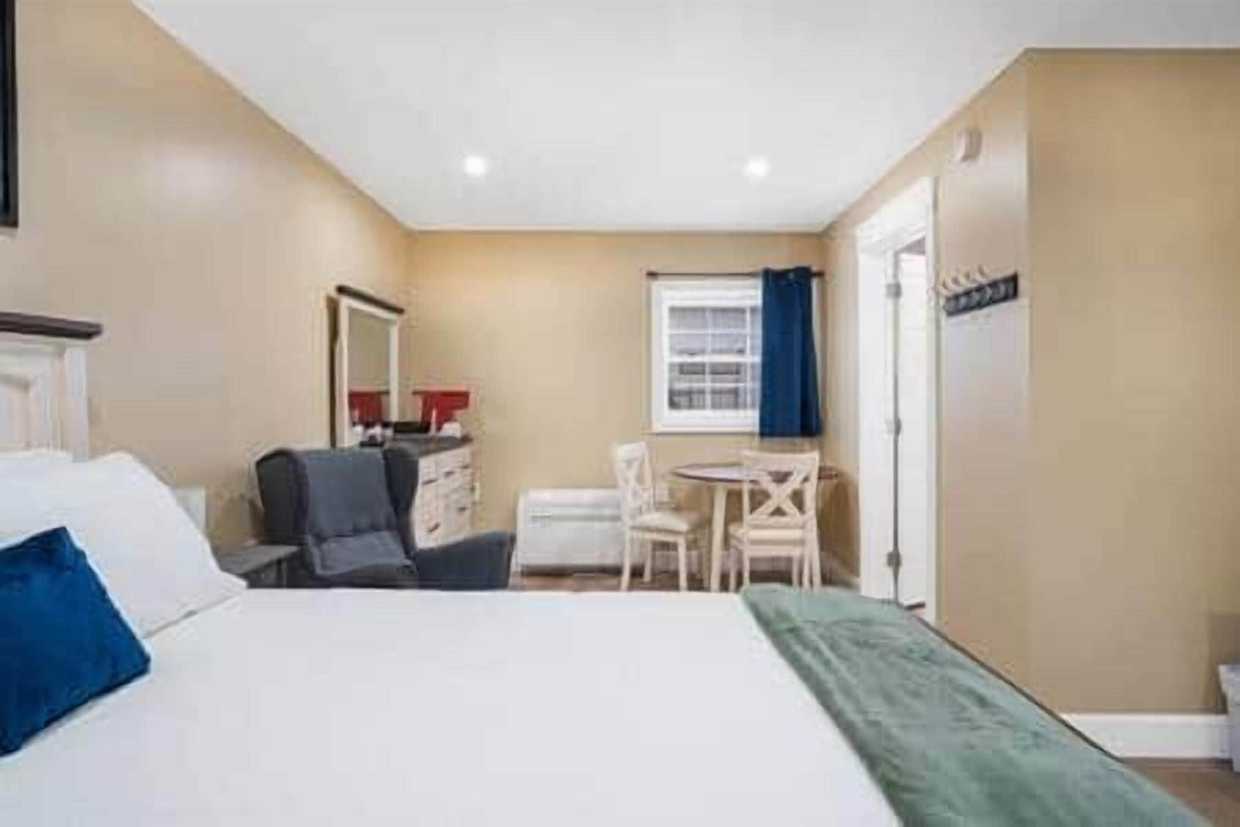 A hotel room with a bed, a desk, and a chair.