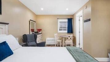 A hotel room with a bed, a desk, and a chair.