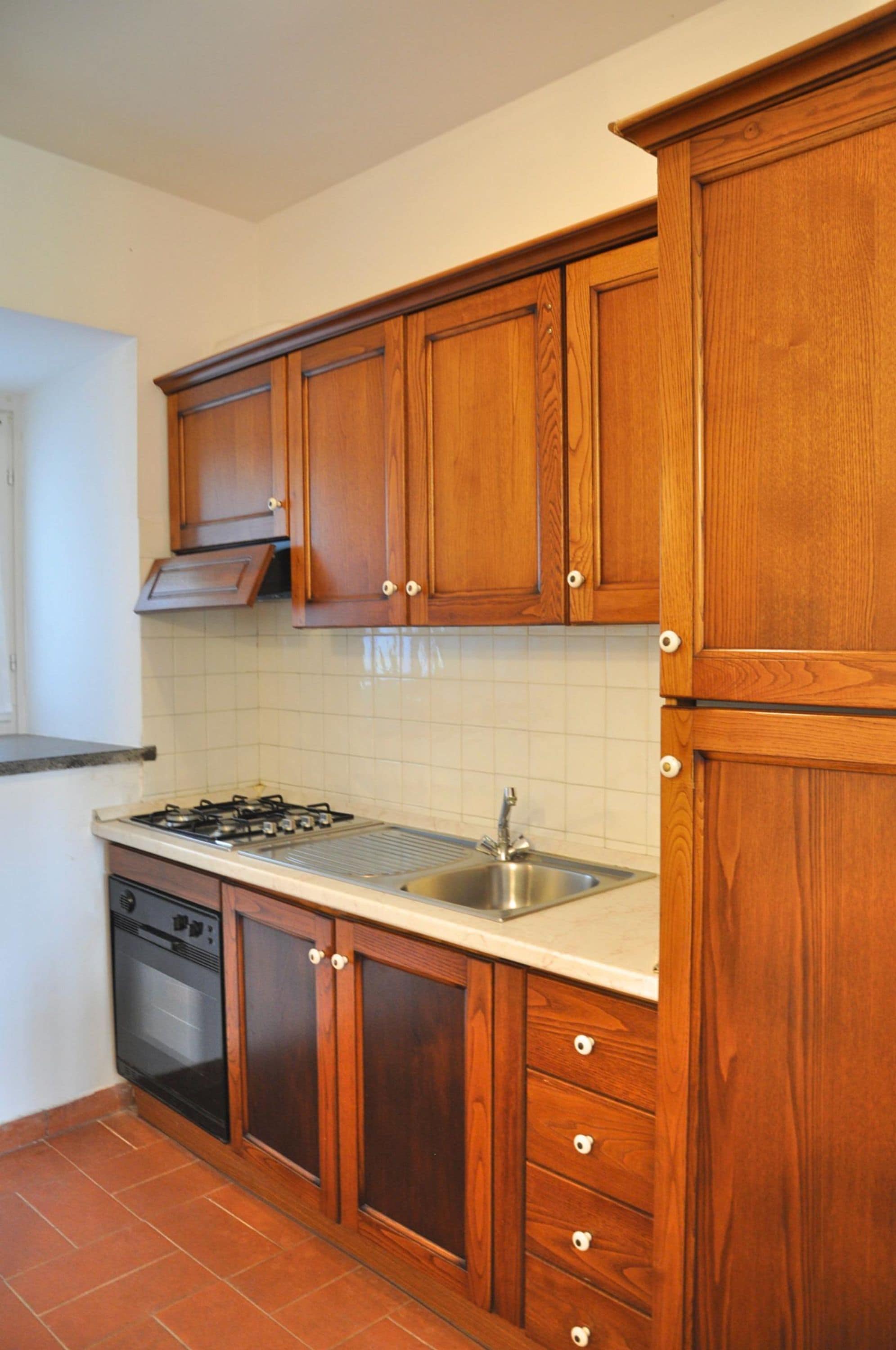 A kitchen with wooden cabinets, a stainless steel sink, a gas stove, and a dishwasher.