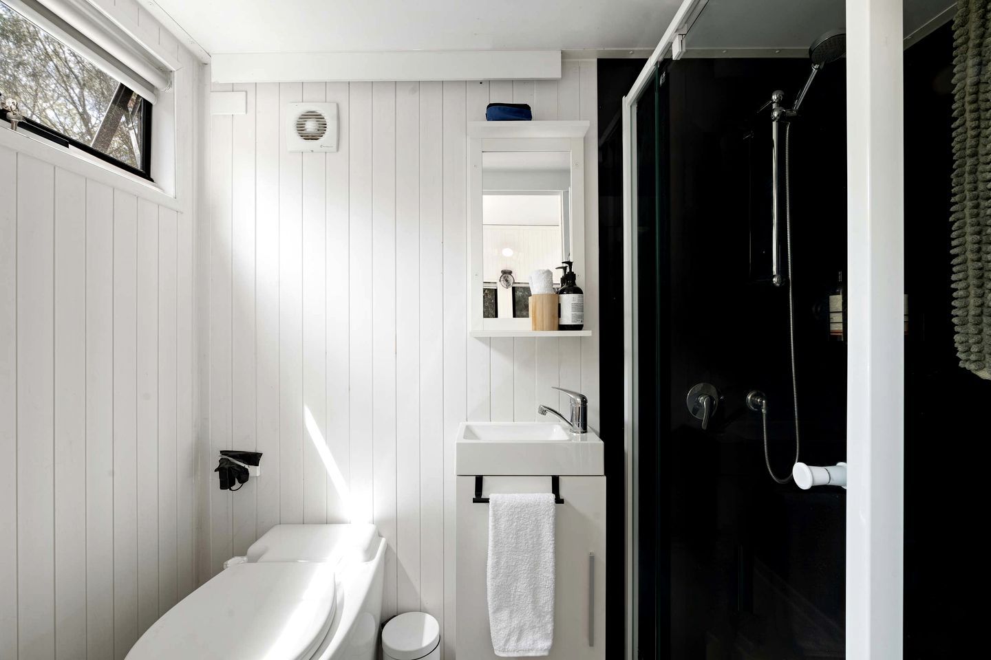 Une salle de bain avec une baignoire blanche, un lavabo et une douche à parois de verre.