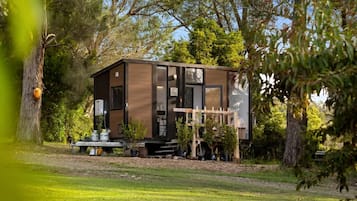 A modern, two-story house with a deck and a small garden area.