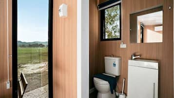 Un baño con inodoro, lavamanos y ventana.