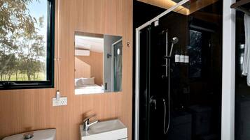 A modern bathroom with a sink, mirror, and shower.