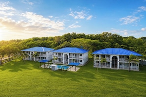 Un gran resort de varios pisos con techos azules, piscina y exuberantes zonas verdes.