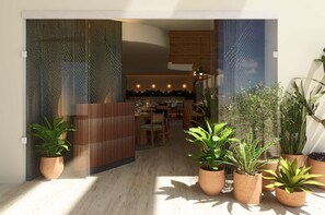 An interior space with a dining area, potted plants, and a wooden partition. - Tivoli Mérida Residences (Mérida)