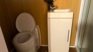 A compact bathroom with a toilet and a small cabinet.