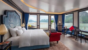 Un dormitorio amplio con una cama grande, vista al agua y un balcón.