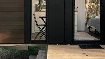 A compact, modern cabin with a sliding glass door leading to a small kitchen area.