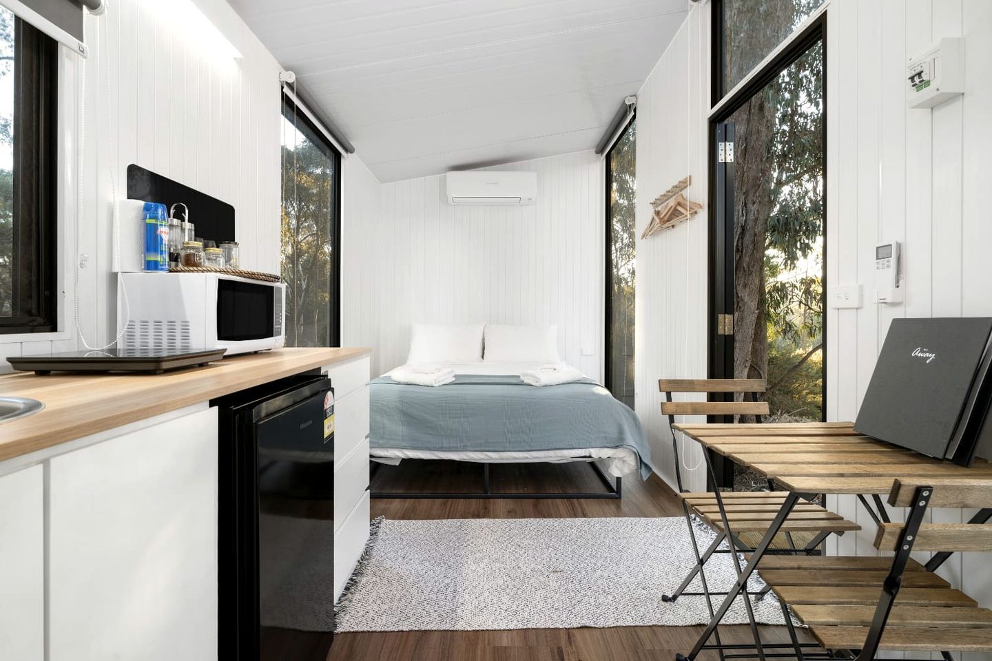 Ein gemütliches Schlafzimmer mit Bett, Schreibtisch und Fenster.