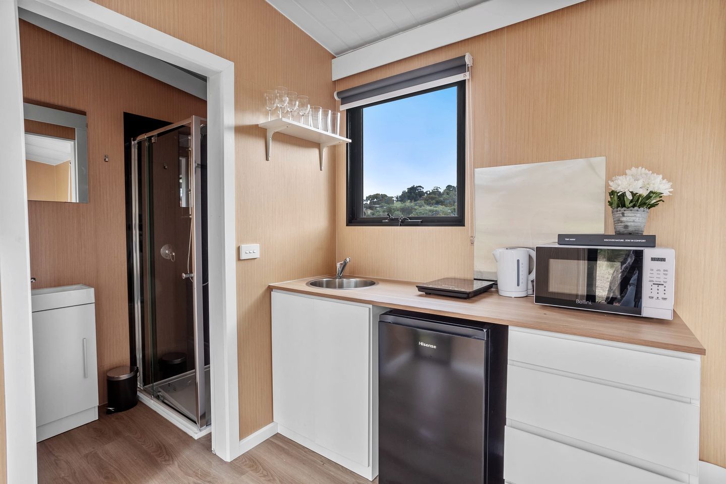 A compact kitchen with a sink, a microwave, and a dishwasher.