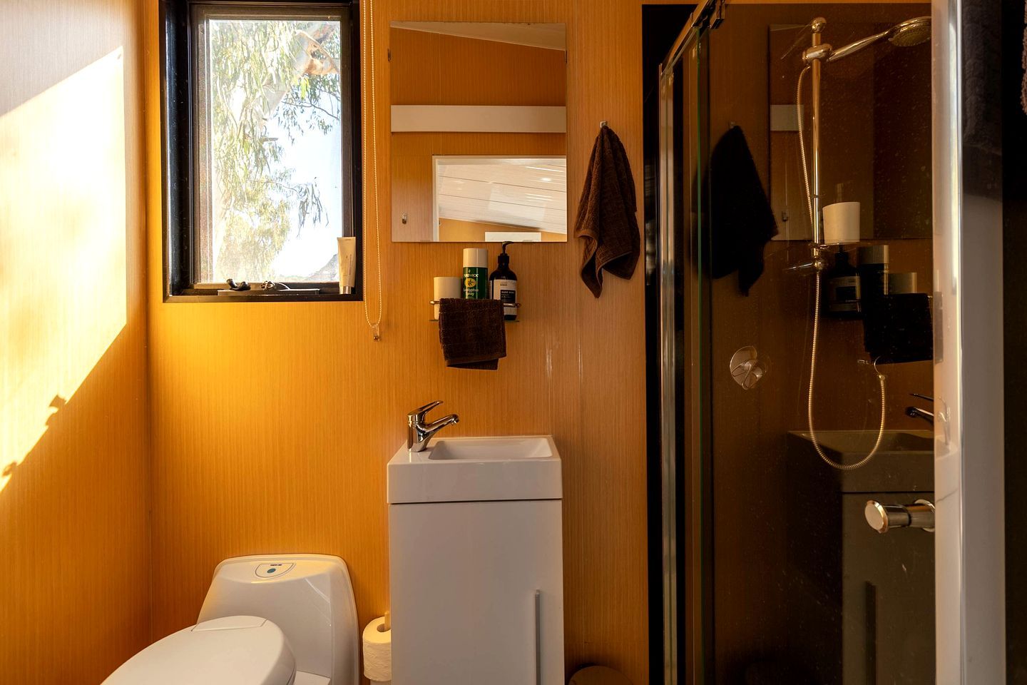 Une petite salle de bain comprenant des toilettes, un lavabo et une douche.