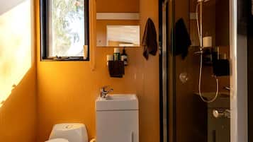 Une petite salle de bain comprenant des toilettes, un lavabo et une douche.