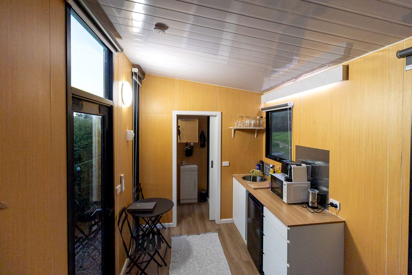 A compact kitchen with a dining area, a small refrigerator, and a microwave.