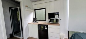 A compact kitchenette with a microwave, toaster, and sink.