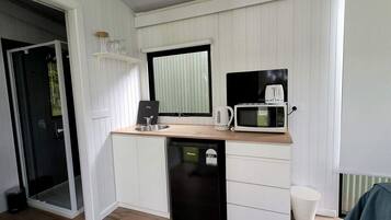 A compact kitchenette with a microwave, toaster, and sink.