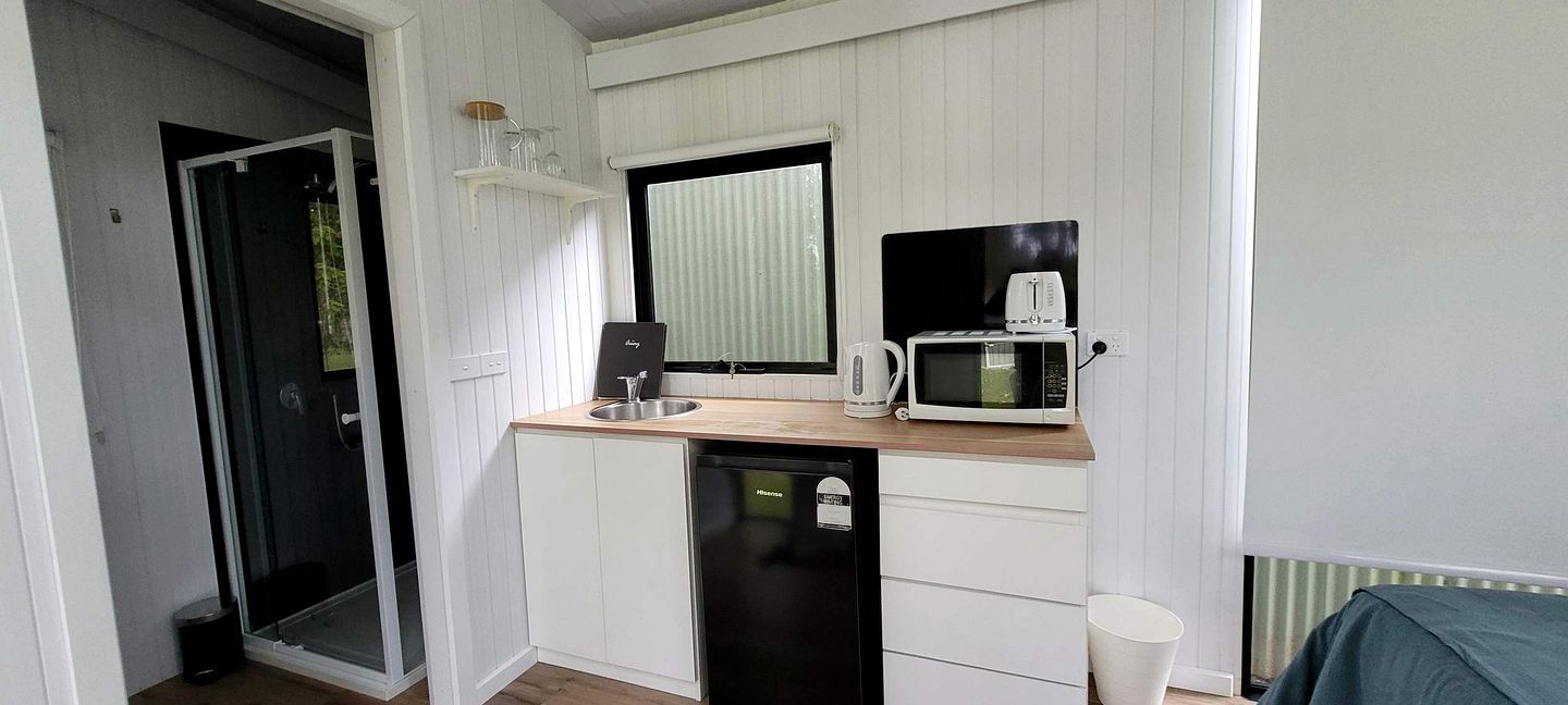 A compact kitchenette with a microwave, toaster, and sink.